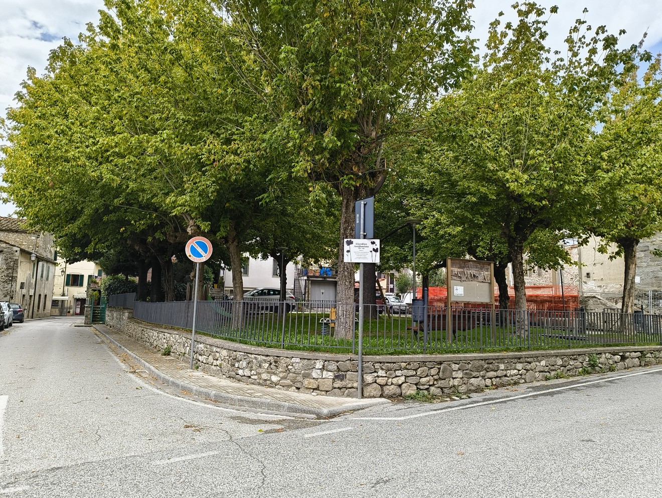 Un giardino pubblico con alberi, simbolo di resistenza e memoria antifascista, in un contesto urbano.