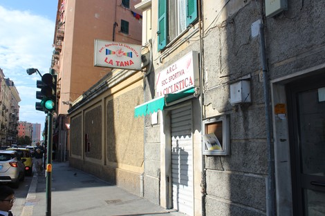Targa che indica "La Tana" con dettagli architettonici caratteristici in un contesto cittadino.