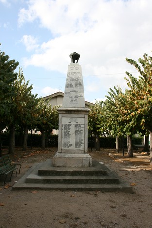 Monumento ai caduti di Asciano, dedicato alla memoria dei soldati nella guerra, circondato da alberi.