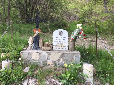 Cippo commemorativo per Giovanni Azzaretti, partigiano morto per la libertà, situato in un'area verde.