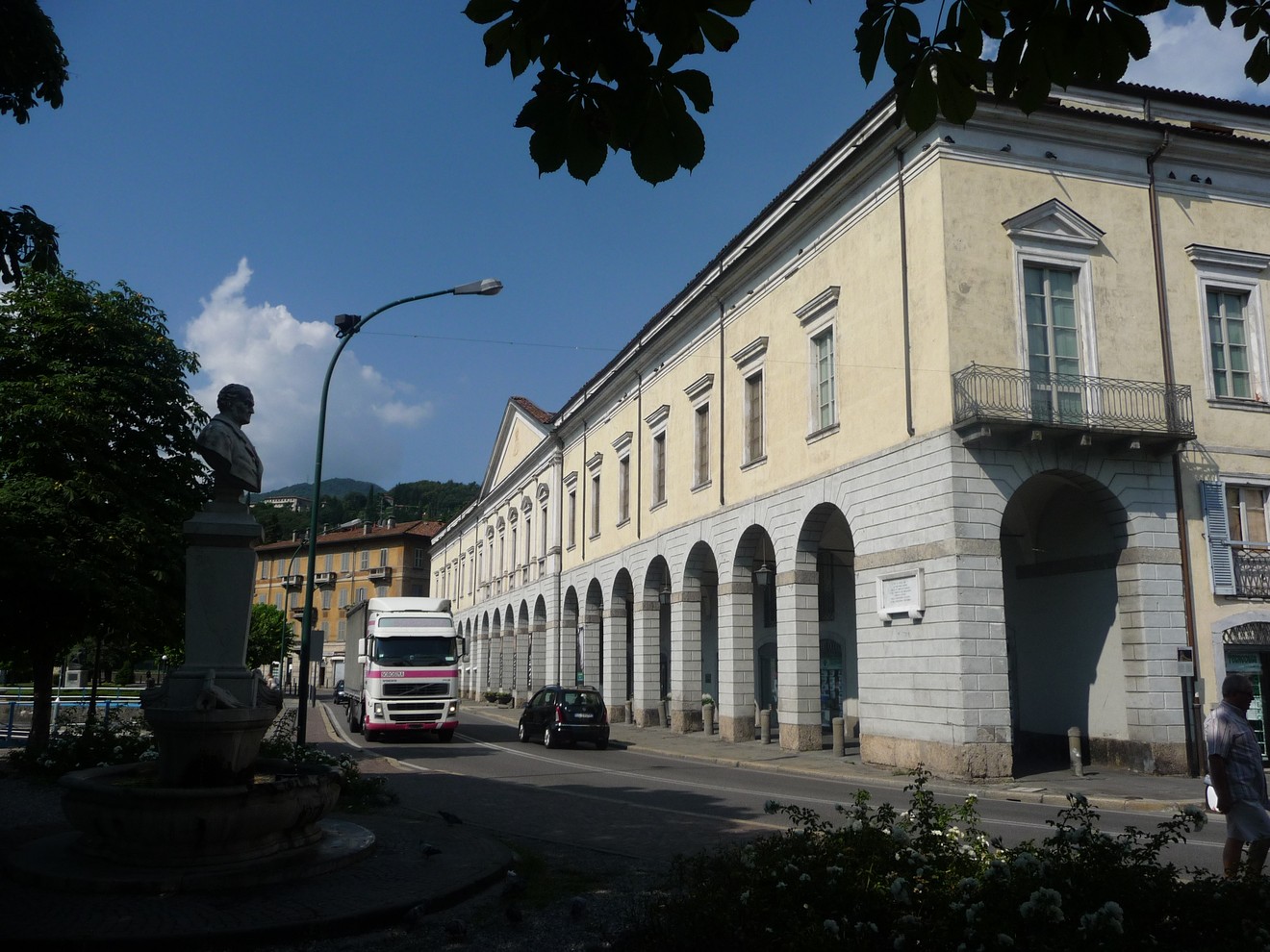 Lapide commemorativa situata a Lovere, circondata da un contesto urbano e vegetazione.