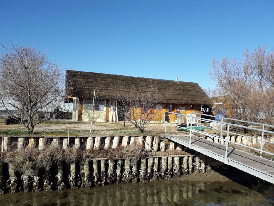 Isola degli Spinaroni: vista della tradizionale casa con tetto di paglia e il ponte che conduce alla riva.