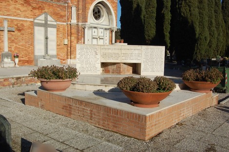 Sacrario delle vittime civili, monumento commemorativo con nicchie e piante ornamentali. Atmosfera di rispetto e memoria.