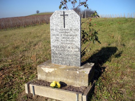 Cippo commemorativo dedicato a Paolina Magni, situato in un paesaggio rurale.