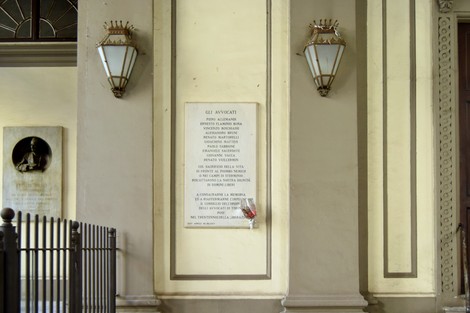Lapide commemorativa dedicata agli avvocati caduti o internati, situata in un contesto architettonico.