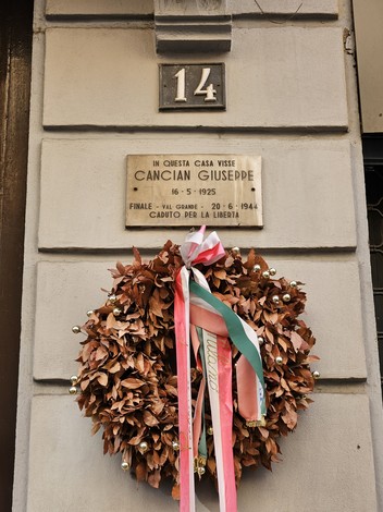 Lapide commemorativa di Cancian Giusepppe con una ghirlanda di foglie e nastri. Memoriale a un caduto per la libertà.