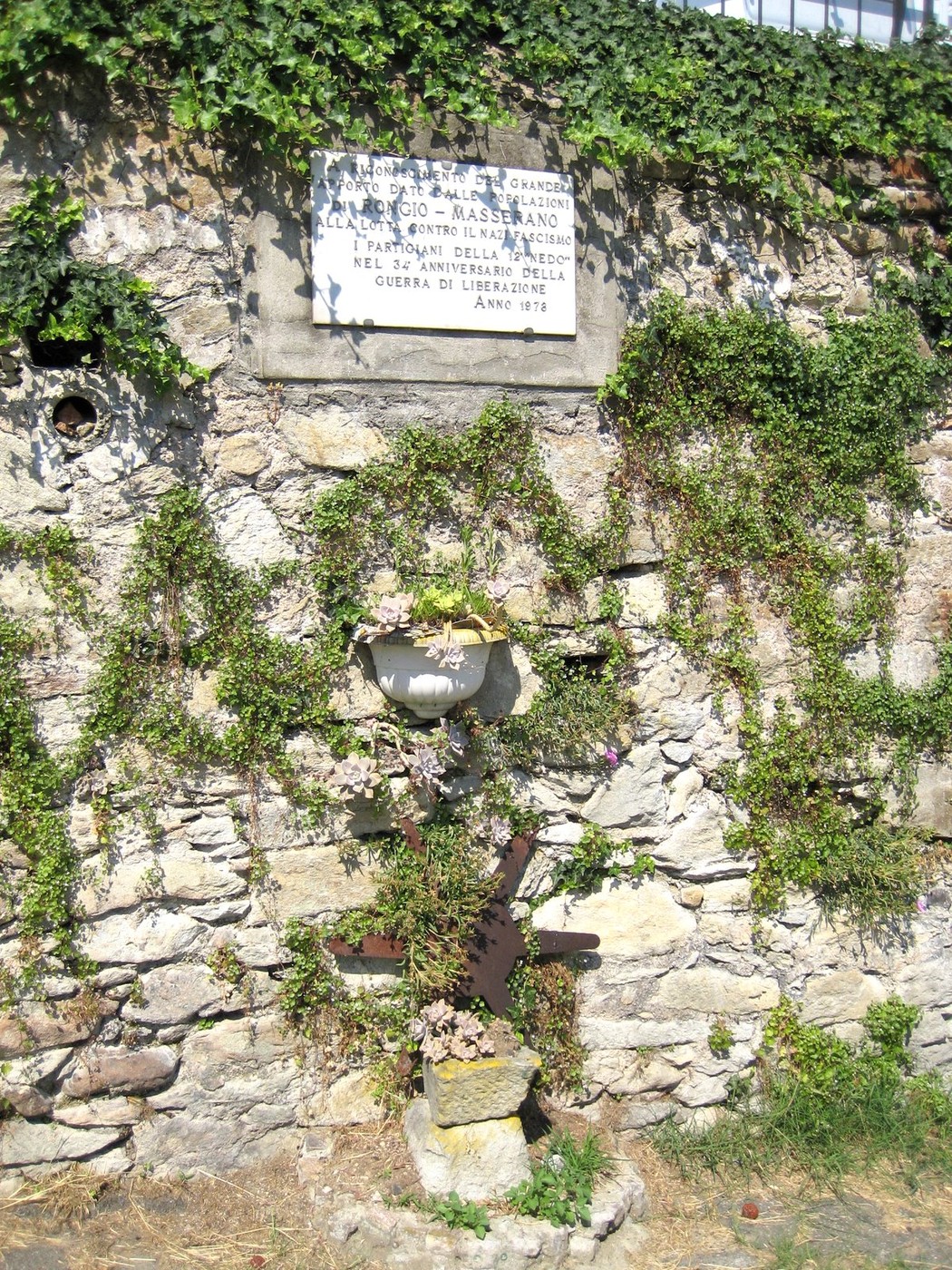 Lapide commemorativa dedicata al contributo dei partigiani nella Resistenza durante la Seconda Guerra Mondiale.