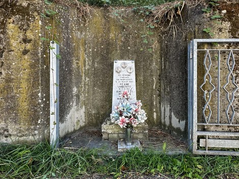 Cippo commemorativo dedicato a Marchesi, Andreotti e Reami, situato in un'area verde contemplativa.