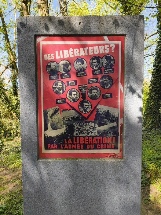 Memoriale del Gruppo Manouchian con immagini e testi commemorativi in un contesto naturale.