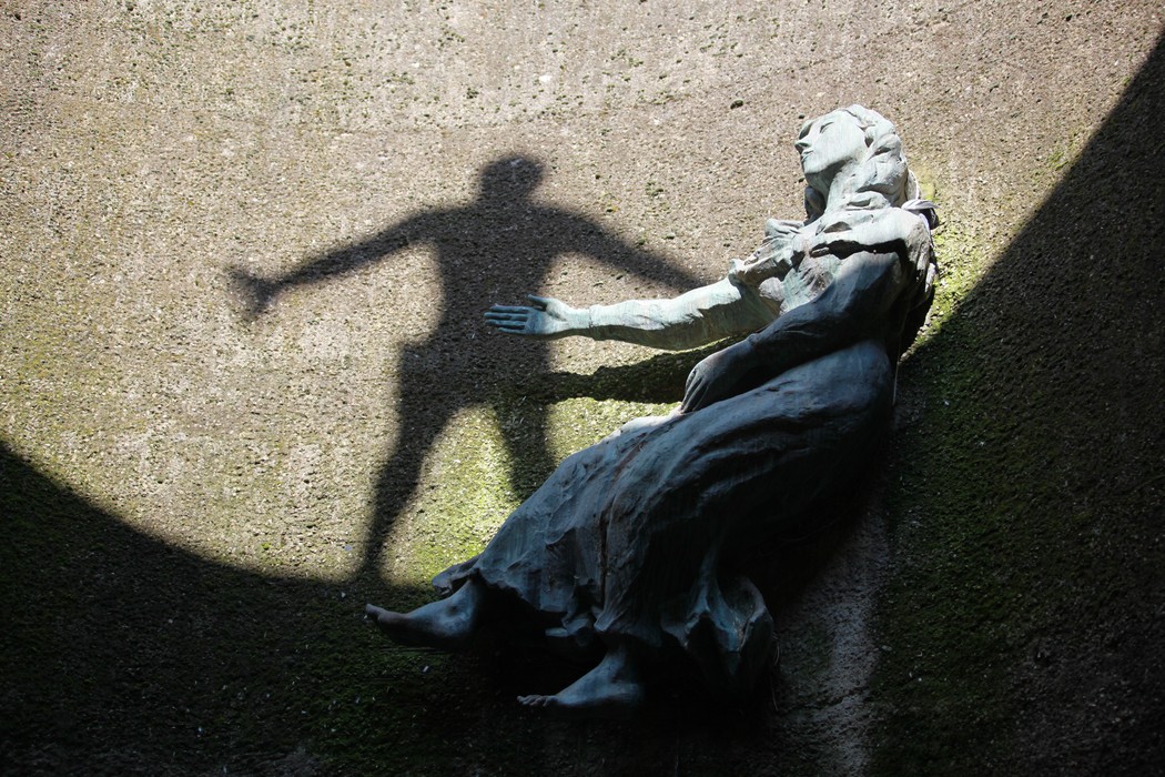 Monumento Ossario dei caduti partigiani, rappresentazione scultorea evocativa con giochi di luce e ombre.