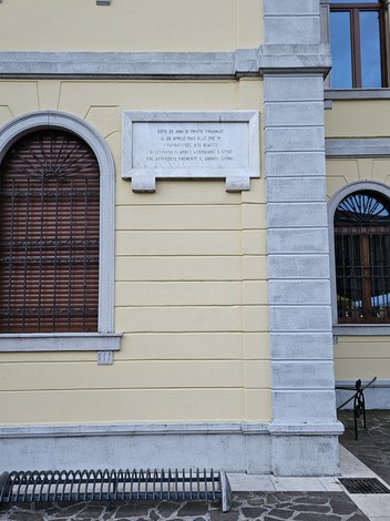 Lapide commemorativa dedicata all'Insurrezione, affissa su muro di un edificio storico.