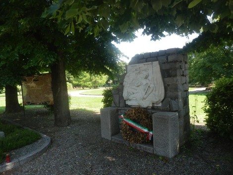 Pannello commemorativo ai caduti, circondato da alberi e un ambiente sereno, dedicato alla Libertà.