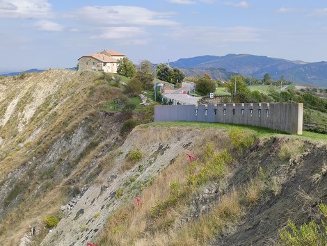 Monumento ai partigiani caduti a Monte Sabbiuno, con vista panoramica sul paesaggio circostante.