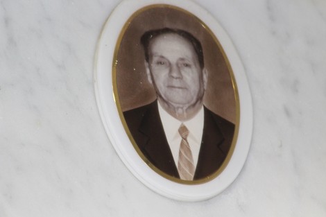 Fotografia di un ovale con un ritratto di un uomo in abito formale, inserito in una cornice su sfondo marmoreo.