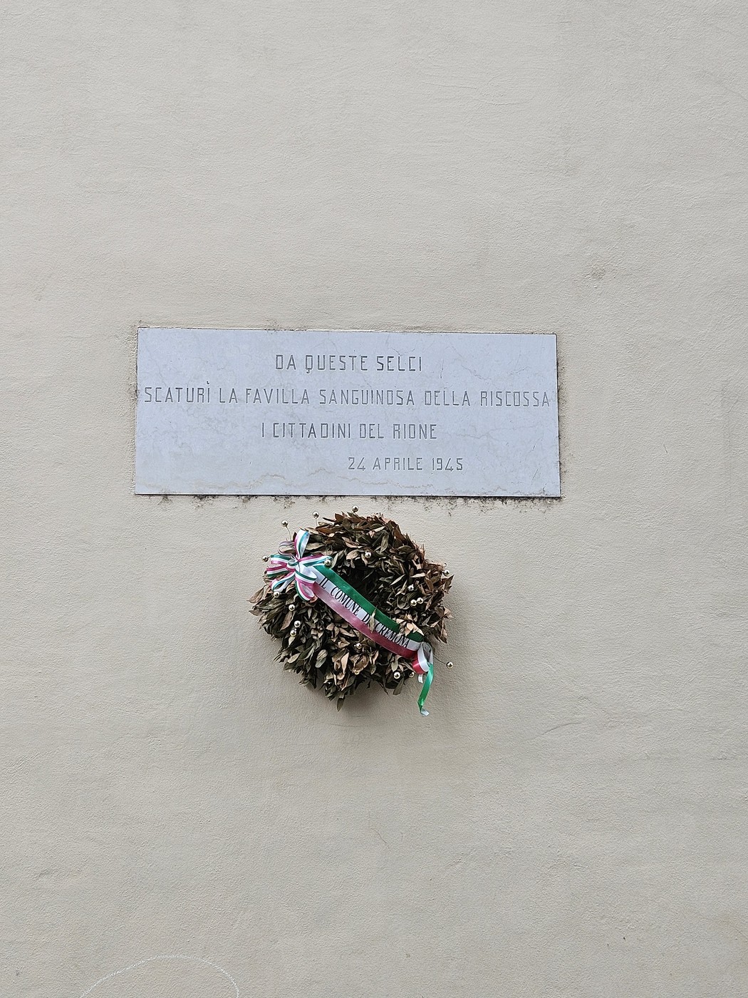 Lapide commemorativa con corona di fiori, dedicata all'insurrezione del 1945.