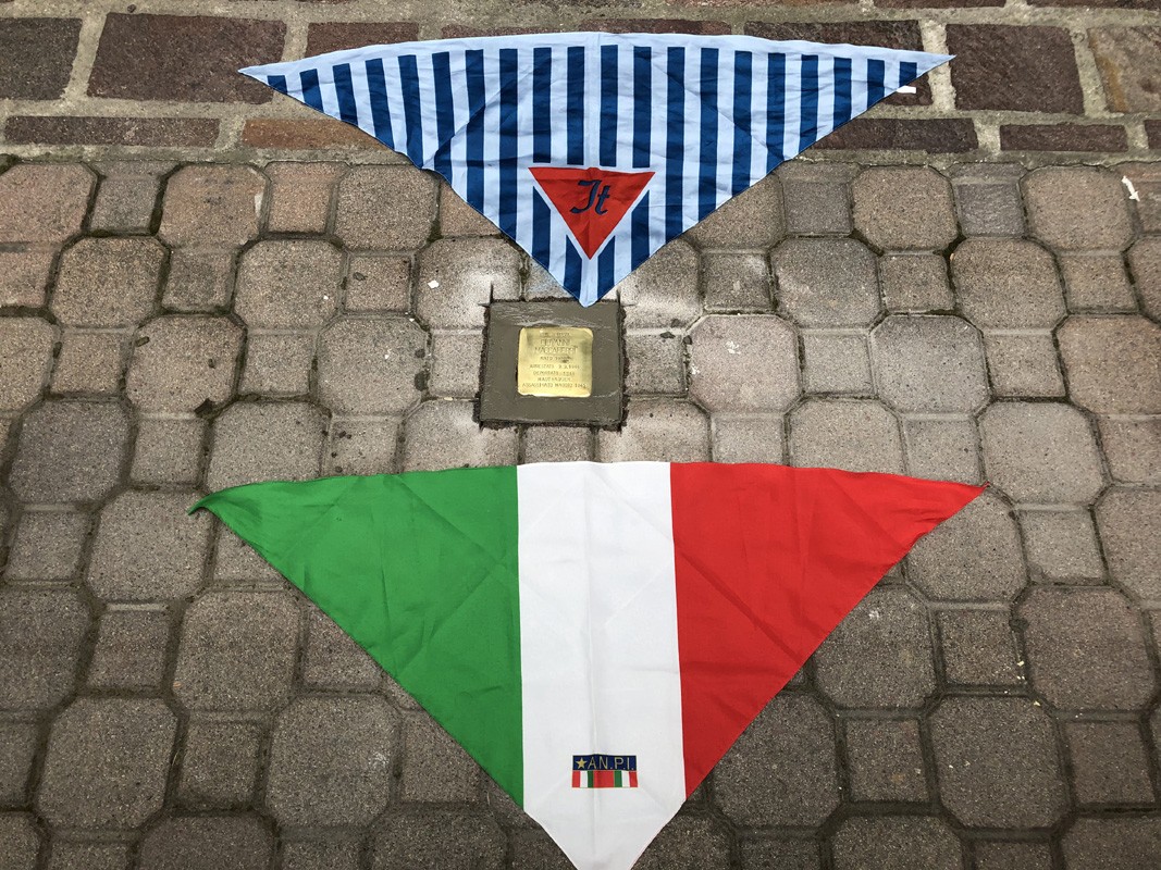 Pietra d'inciampo a Maccaferri con bandiere disposte in verticale, simbolo di memoria e riconoscimento.