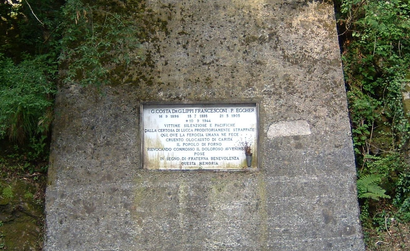 Lapide commemorativa dedicata ai frati della Certosa di Lucca, situata in un contesto naturale ricco di storia.