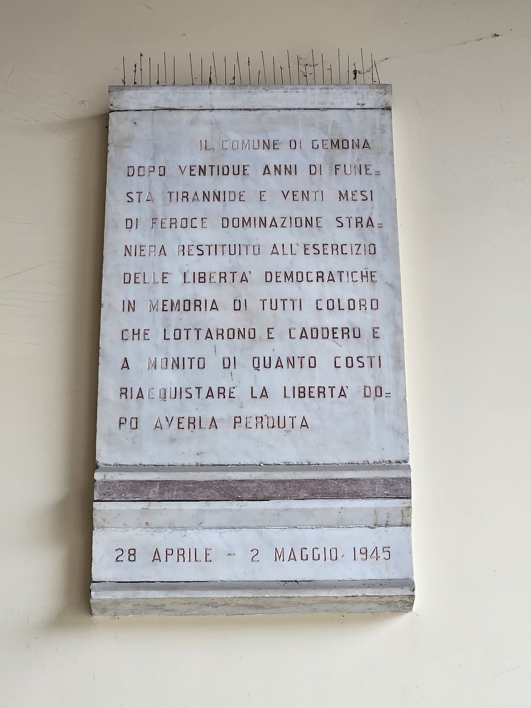 Lapide commemorativa che ricorda la Resistenza, con iscrizioni sulla libertà e i sacrifici fatti.