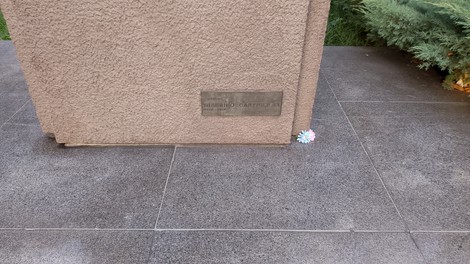 Monumento ai martiri di Piazzale Loreto, commemorazione storica con base in pietra e decorazioni floreali.