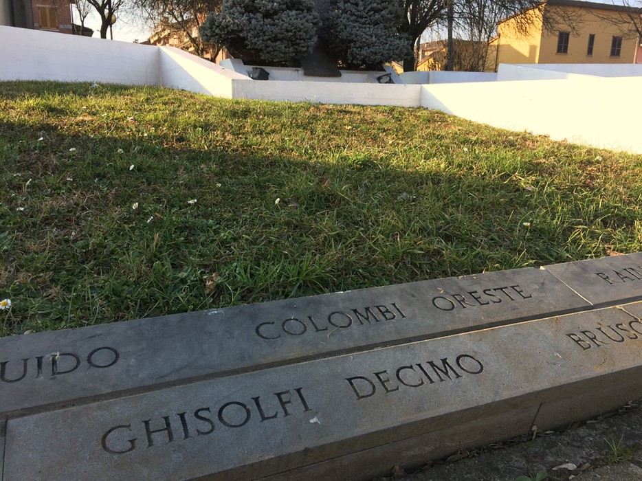 Monumento ai caduti di Travacò Siccomario, con un'area verde e iscrizioni commemorative su una stele.