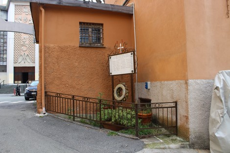 Lapide commemorativa ai caduti della Croce bianca, situata in un angolo tranquillo di un edificio.