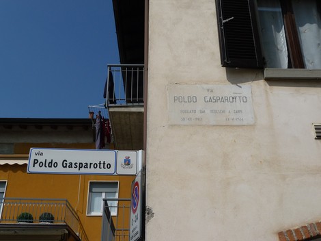 Lapide commemorativa dedicata a Gasparotto, visibile su un edificio lungo la via omonima.