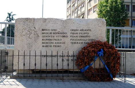 Monumento commemorativo della strage di Avenza, con nomi delle vittime e un corona di fiori.