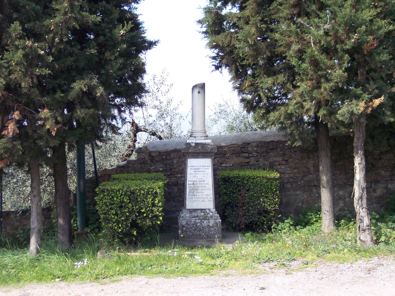 Cippo commemorativo ai caduti, immerso nel verde, a San Gersolé, in un contesto storico e naturalistico.