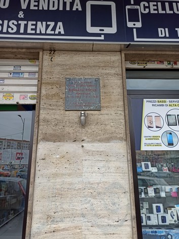Lapide commemorativa situata all'esterno di un negozio di elettronica a Borgesa.