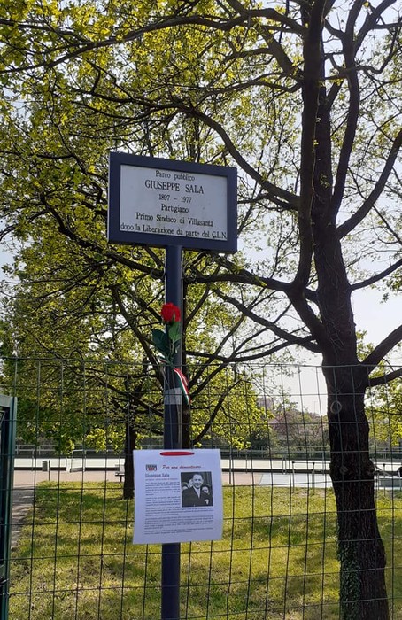Targa commemorativa dedicata a Giuseppe Sala, circondata da un albero e recintata in un parco.