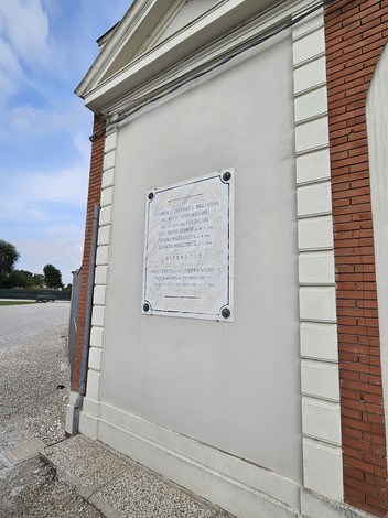 Lapide commemorativa di Zerbini, Mazzanti e Donati, situata in un contesto architettonico semplice.