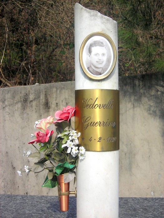 Monumento ai martiri della Garella, in memoria di Vedovelli Guerrino, con fiori e immagine commemorativa.