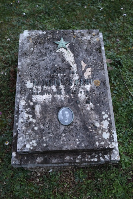 Tomba commemorativa di un partigiano nel Sacrario dei partigiani pratesi, con decorazioni e simboli patriottici.
