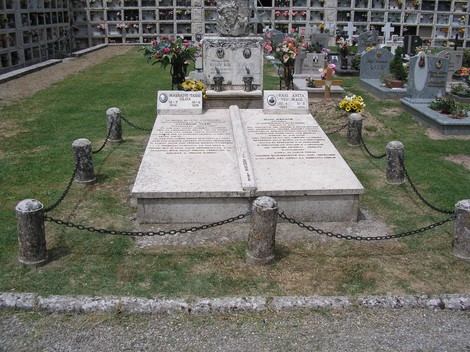 Sepolcro di Magi e Tassi, un luogo di ricordo circondato da fiori e avvolto da una catena di protezione.