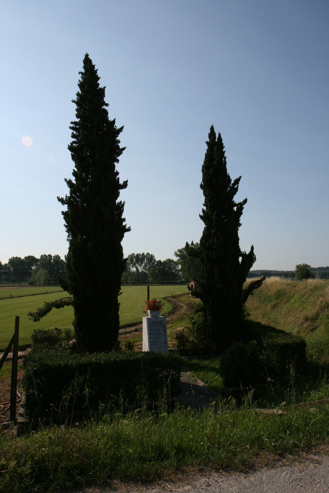 Cippo del Piaggione, monumento circondato da cipressi in un paesaggio rurale, simbolo di memoria storica.