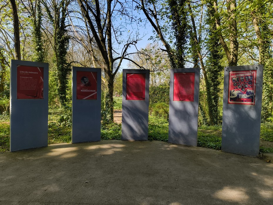 Memoriale del Gruppo Manouchian circondato da alberi, con pannelli informativi su storia e impegno.