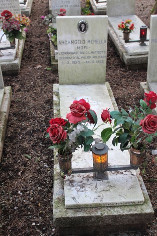 Tombe decorate con fiori, illuminazione e lapidi in memoria dei caduti per la libertà.