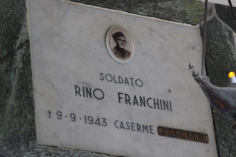 Sacrario dei caduti per la Liberazione, con monumento marmoreo e foto commemorativa di un soldato.