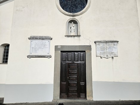 Lapide commemorativa ai caduti, posta sulla facciata di un edificio, con statue e decorazioni.
