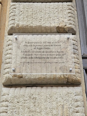 Targa commemorativa sulla Camera del Lavoro di Reggio Emilia, segno della sua storia e delle lotte per i diritti.